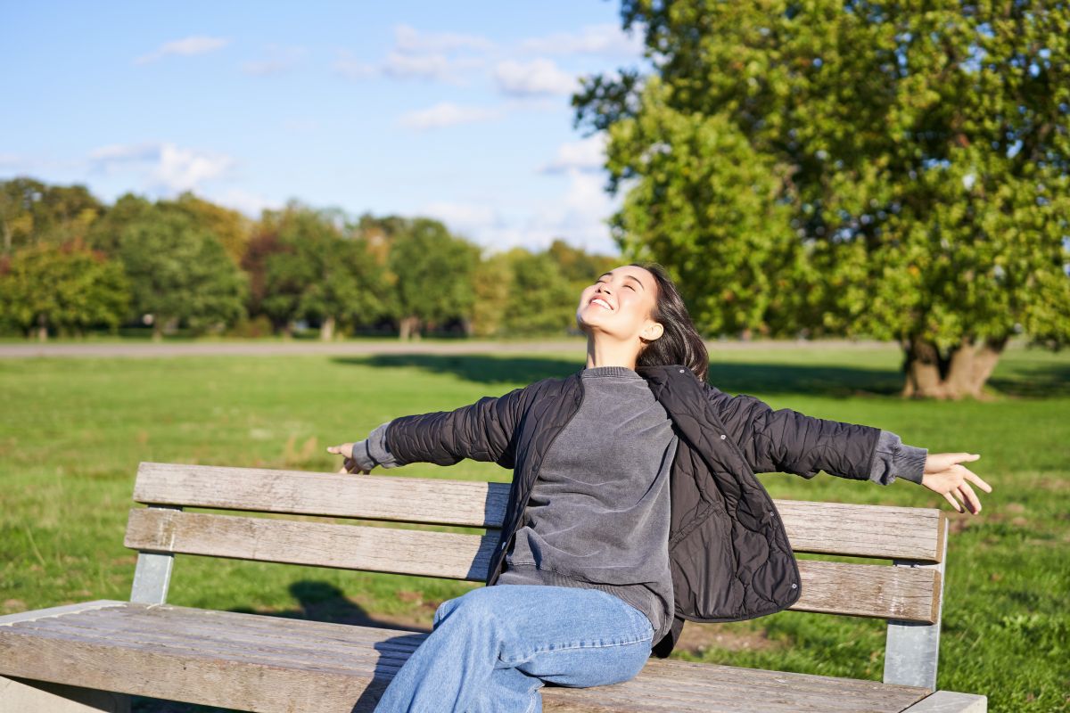 Mujer tomando vitamina D del sol en el parque