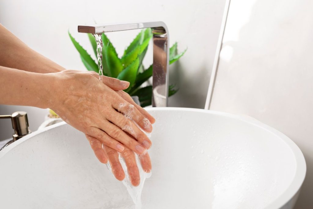 Persona lavándose las manos antes de usar un glucómetro