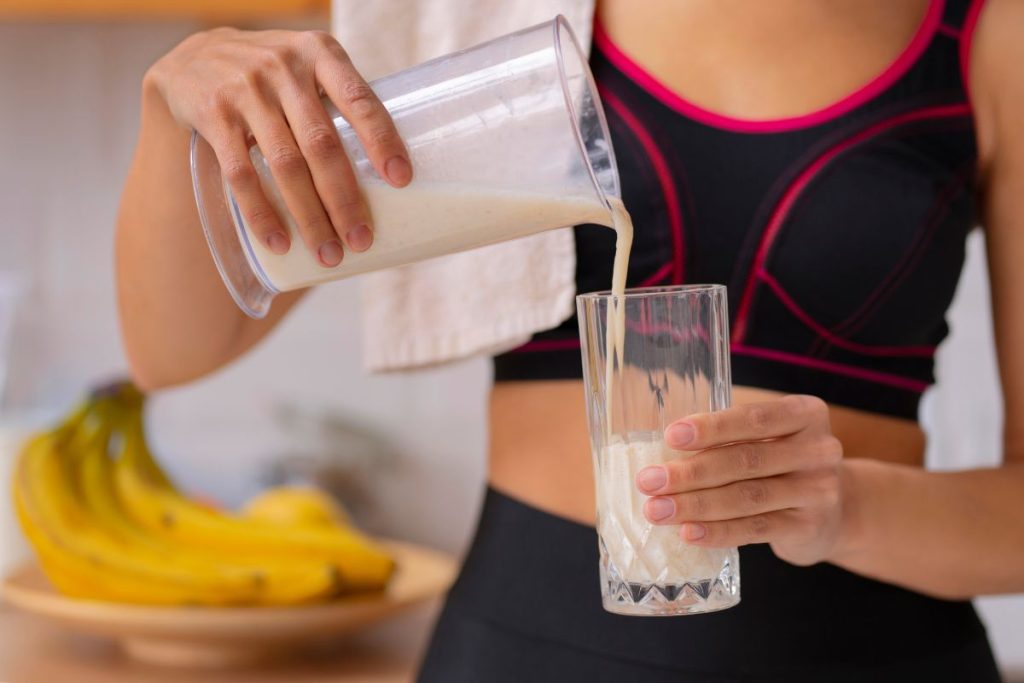 Mujer consumiendo proteínas el polvo